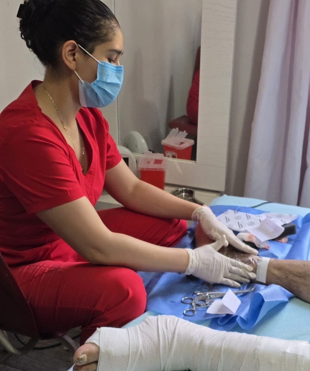 Judith Fajardo realizando una curación de herida en el domicilio de un paciente